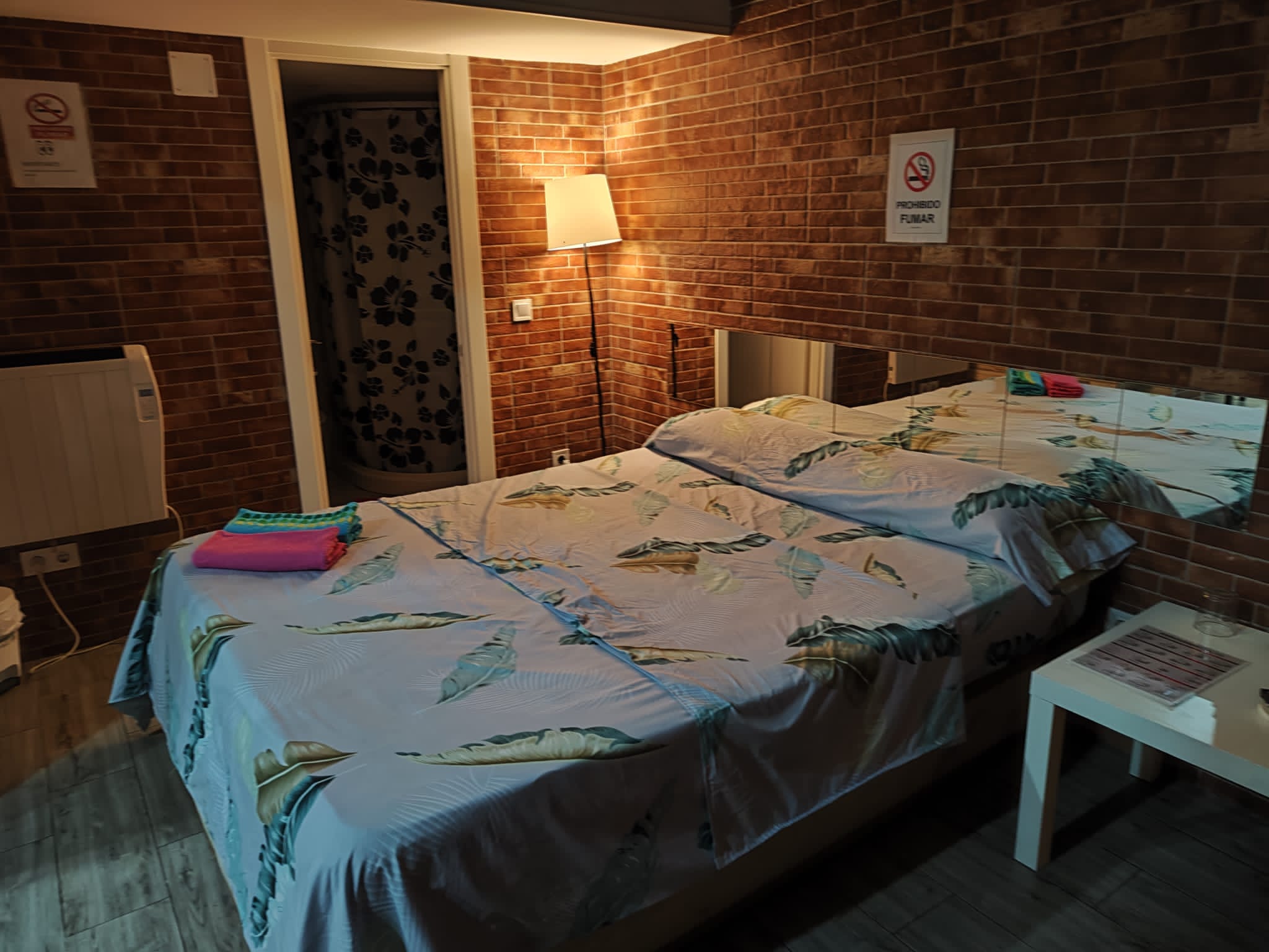 Portazgo Rooms Madrid habitacion a ladrillo visto con cama de sabanas blancas